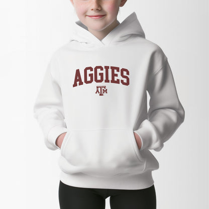 A model wears the White Youth Unisex Texas A&M Aggies Collegiate Hooded Sweatshirt.  The ﻿Texas A&M Aggies Collegiate﻿ graphic is in bold Maroon in a Varsity style.