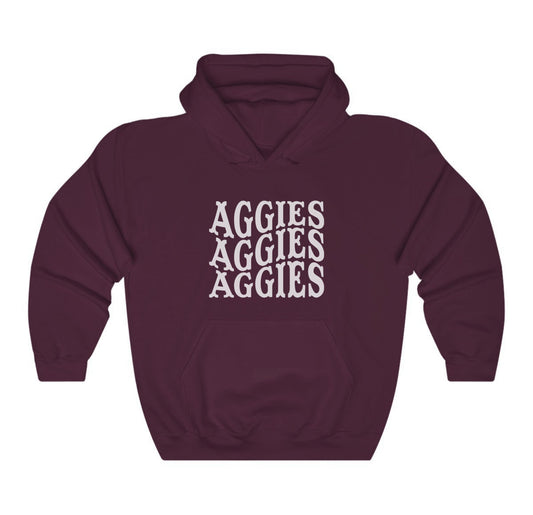 The Maroon Adult Unisex Texas A&M Aggies Aggies Aggies Western Hooded Sweatshirt lays flat on a white background. The ﻿Texas A&M Aggies Aggies Aggies Western﻿ graphic is in bold White in a Western style.