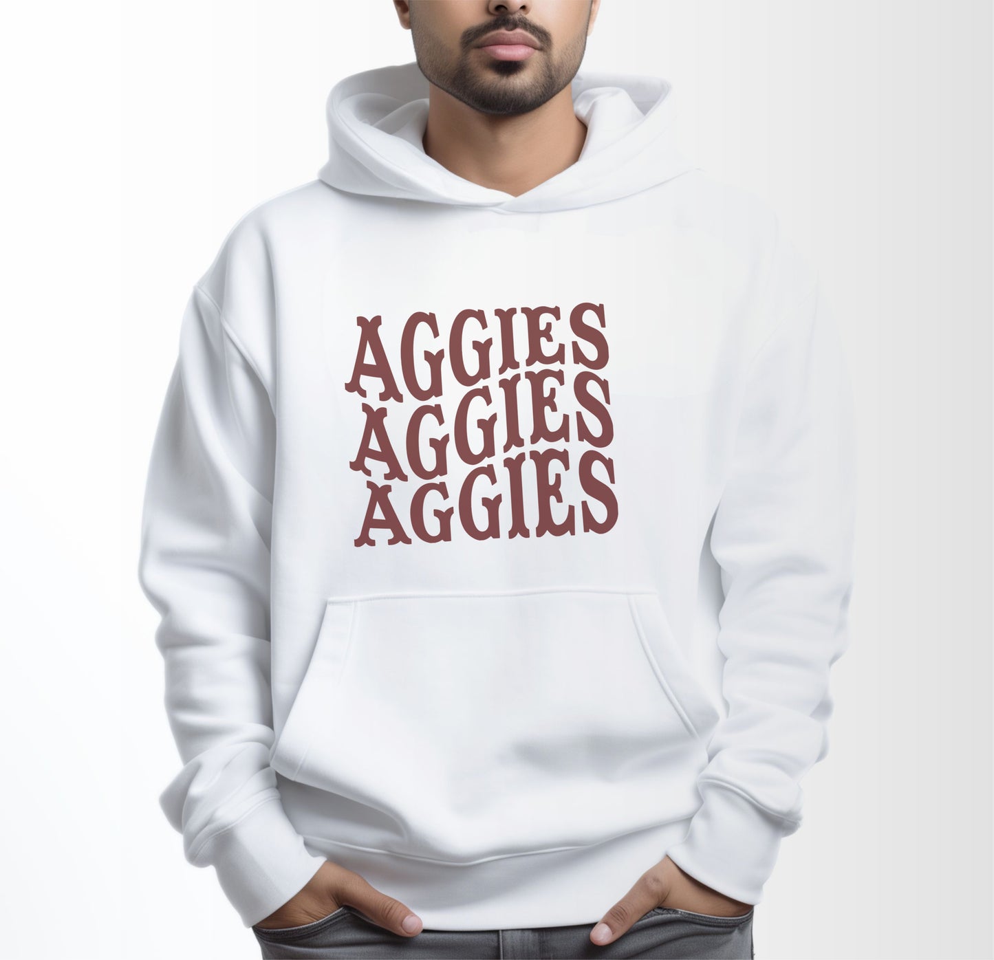 A model wears the White Adult Unisex Texas A&M Aggies Aggies Aggies Western Hooded Sweatshirt.  The ﻿Texas A&M Aggies Aggies Aggies Western﻿ graphic is in bold Maroon in a Western style.