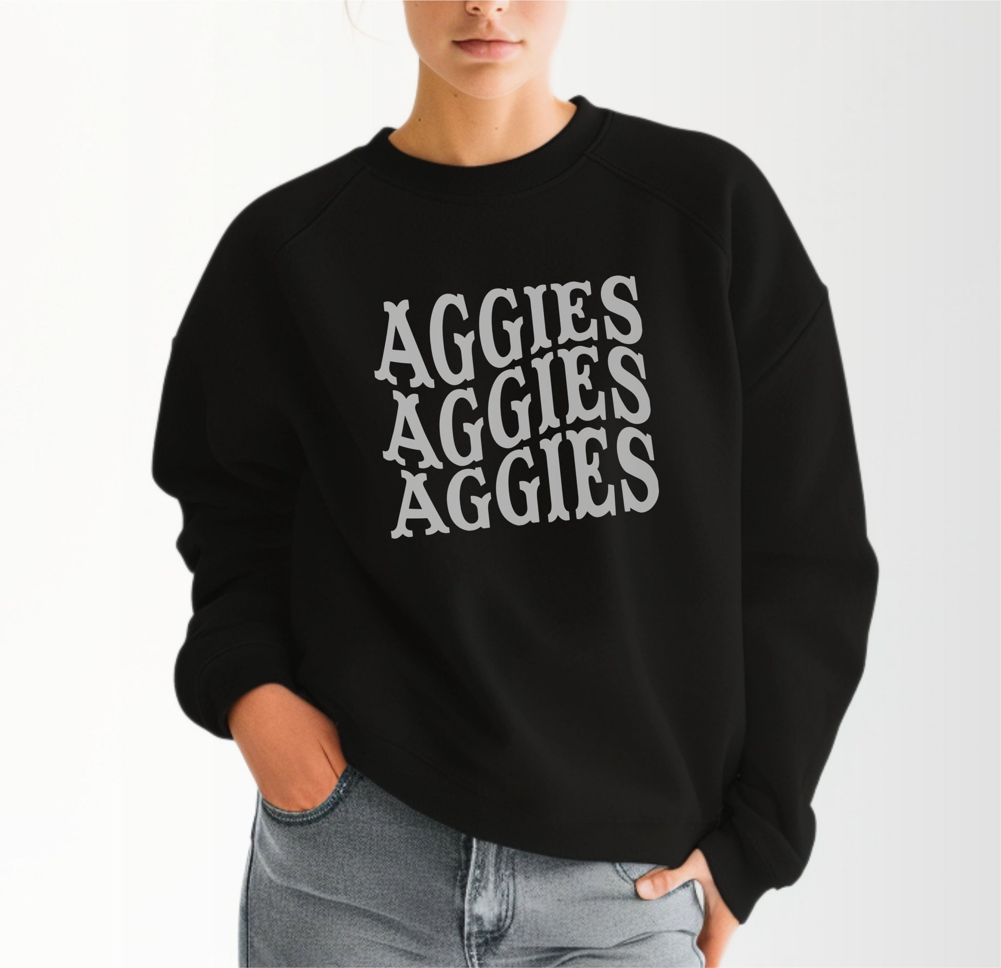 A model wears the Black Adult Unisex Texas A&M Aggies Aggies Aggies Western Crewneck Sweatshirt.  The ﻿Texas A&M Aggies Aggies Aggies Western﻿ graphic is in bold White in a Western style.