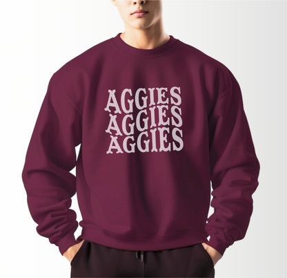 A model wears the Maroon Adult Unisex Texas A&M Aggies Aggies Aggies Western Crewneck Sweatshirt.  The ﻿Texas A&M Aggies Aggies Aggies Western﻿ graphic is in bold White in a Western style.