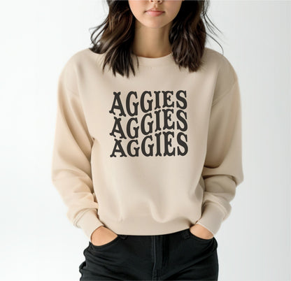 A model wears the Sand Adult Unisex Texas A&M Aggies Aggies Aggies Western Crewneck Sweatshirt.  The ﻿Texas A&M Aggies Aggies Aggies Western﻿ graphic is in bold Black in a Western style.