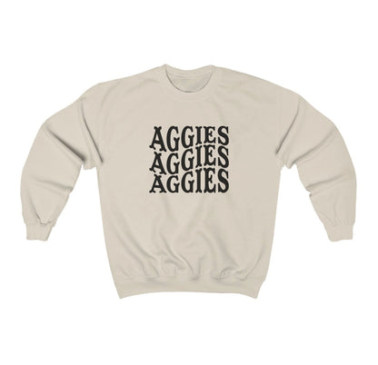 The Sand Adult Unisex Texas A&M Aggies Aggies Aggies Western Crewneck Sweatshirt lays flat on a white background. The ﻿Texas A&M Aggies Aggies Aggies Western﻿ graphic is in bold Black in a Western style.