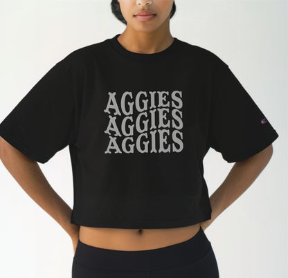 A model wears the Black Adult Womens Texas A&M Aggies Aggies Aggies Western Crop Top.  The ﻿Texas A&M Aggies Aggies Aggies Western﻿ graphic is in bold White in a Western style.