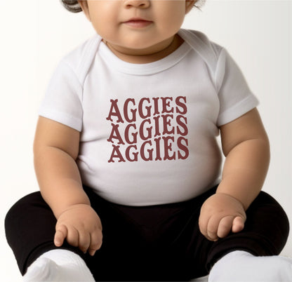 A model wears the White Infant Unisex Texas A&M Aggies Aggies Aggies Western Bodysuit.  The ﻿Texas A&M Aggies Aggies Aggies Western﻿ graphic is in bold Maroon in a Western style.