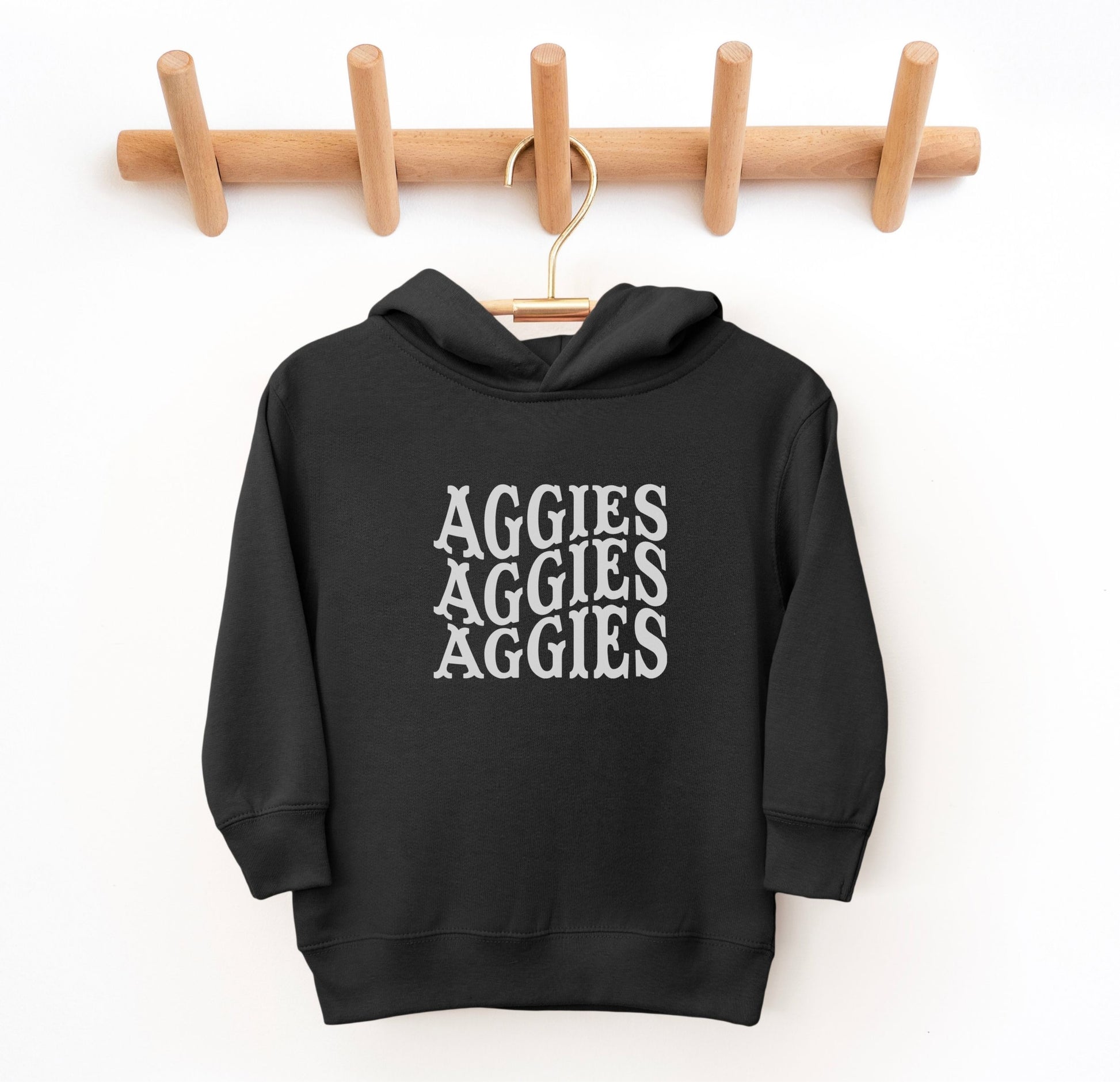 The Black Toddler Unisex Texas A&M Aggies Aggies Aggies Western Hooded Sweatshirt lays flat on a white background. The ﻿Texas A&M Aggies Aggies Aggies Western﻿ graphic is in bold White in a Western style.