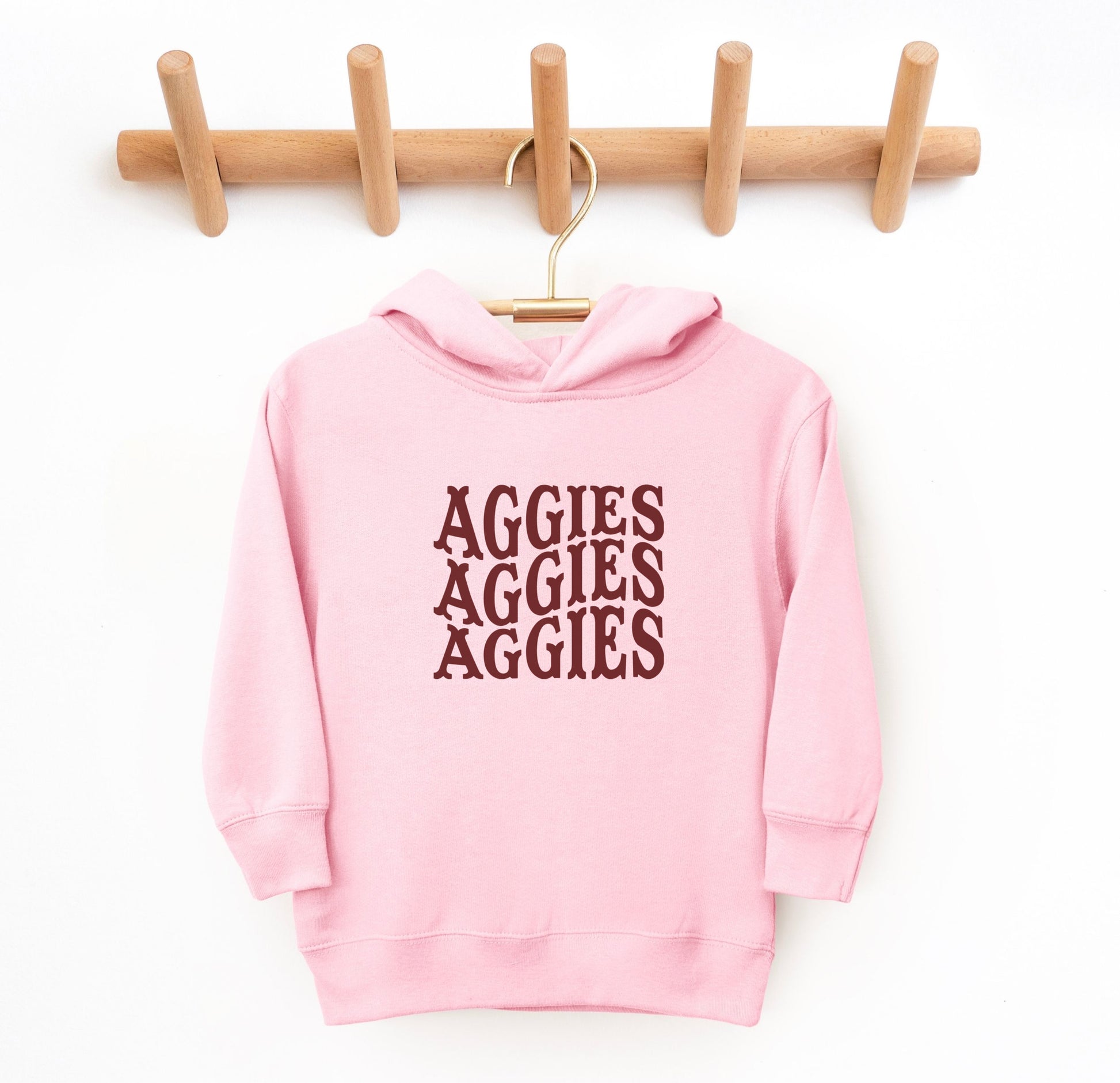 The Pink Toddler Unisex Texas A&M Aggies Aggies Aggies Western Hooded Sweatshirt lays flat on a white background. The ﻿Texas A&M Aggies Aggies Aggies Western﻿ graphic is in bold White in a Western style.