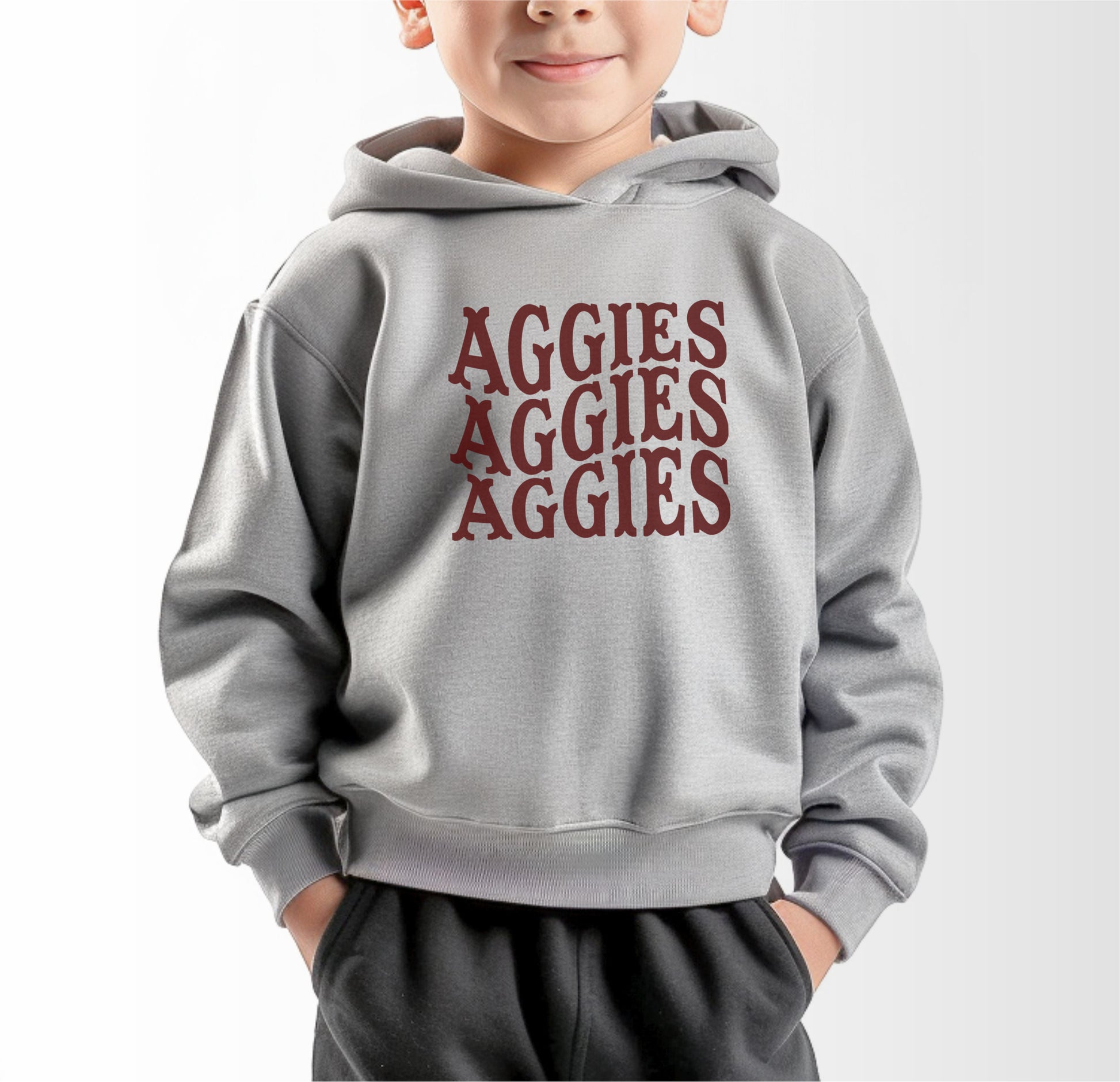 A model wears the Heather Grey Toddler Unisex Texas A&M Aggies Aggies Aggies Western Hooded Sweatshirt.  The ﻿Texas A&M Aggies Aggies Aggies Western﻿ graphic is in bold Maroon in a Western style.