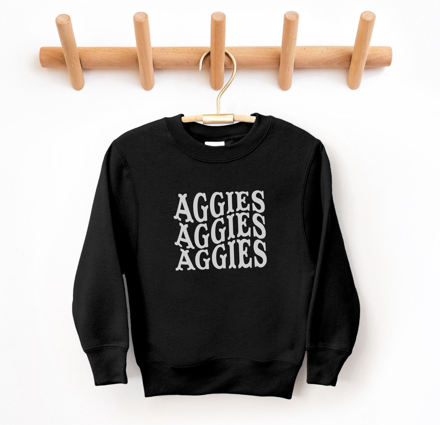 The Black Youth Unisex Texas A&M Aggies Aggies Aggies Western Crewneck Sweatshirt lays flat on a white background. The ﻿Texas A&M Aggies Aggies Aggies Western﻿ graphic is in bold White in a Western style.