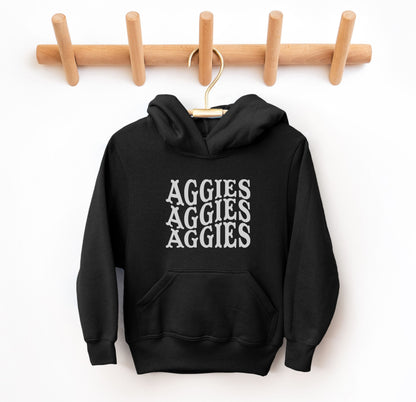 The Black Youth Unisex Texas A&M Aggies Aggies Aggies Western Hooded Sweatshirt lays flat on a white background. The ﻿Texas A&M Aggies Aggies Aggies Western﻿ graphic is in bold White in a Western style.