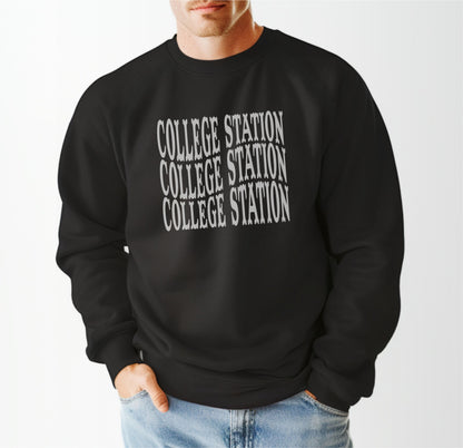 A model wears the Black Adult Unisex College Station Western Crewneck Sweatshirt.  The ﻿College Station Western﻿ graphic is in bold White in a Western style.