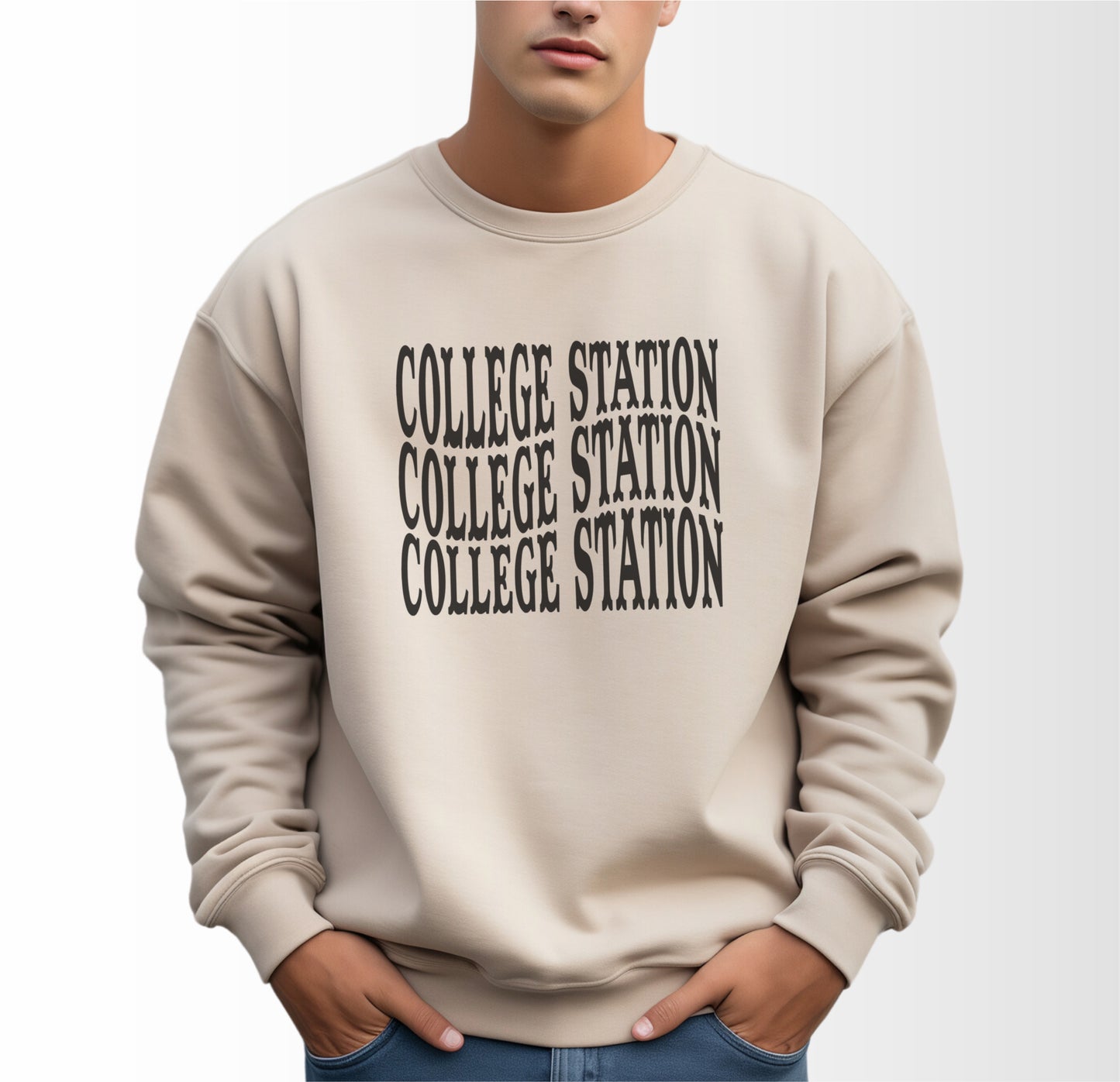 A model wears the Sand Adult Unisex College Station Western Crewneck Sweatshirt.  The ﻿College Station Western﻿ graphic is in bold Black in a Western style.