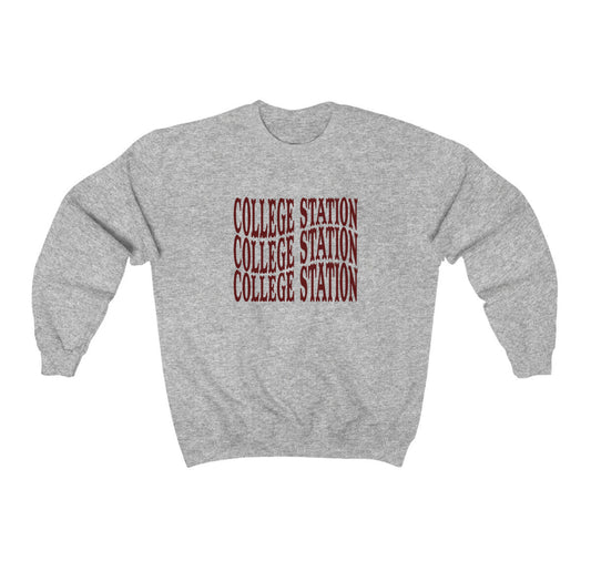 The Sport Grey Adult Unisex College Station Western Crewneck Sweatshirt lays flat on a white background. The ﻿College Station Western﻿ graphic is in bold Maroon in a Western style.