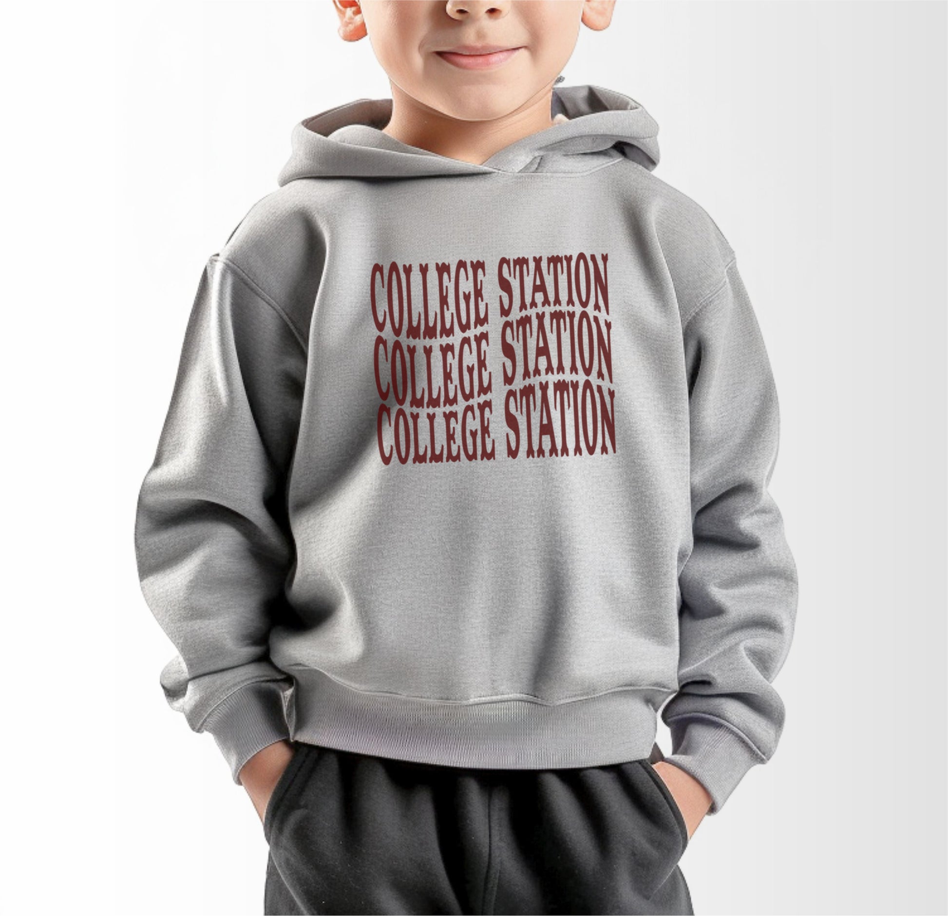 A model wears the Heather Grey Toddler Unisex College Station Western Hooded Sweatshirt.  The ﻿College Station Western﻿ graphic is in bold Maroon in a Western style.