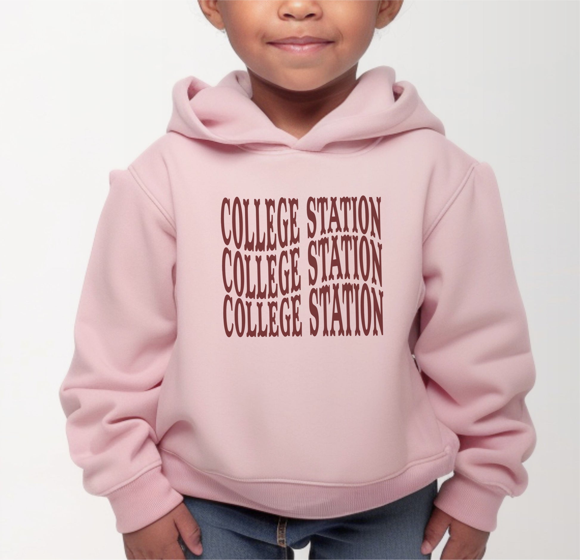 A model wears the Pink Toddler Unisex College Station Western Hooded Sweatshirt.  The ﻿College Station Western﻿ graphic is in bold White in a Western style.