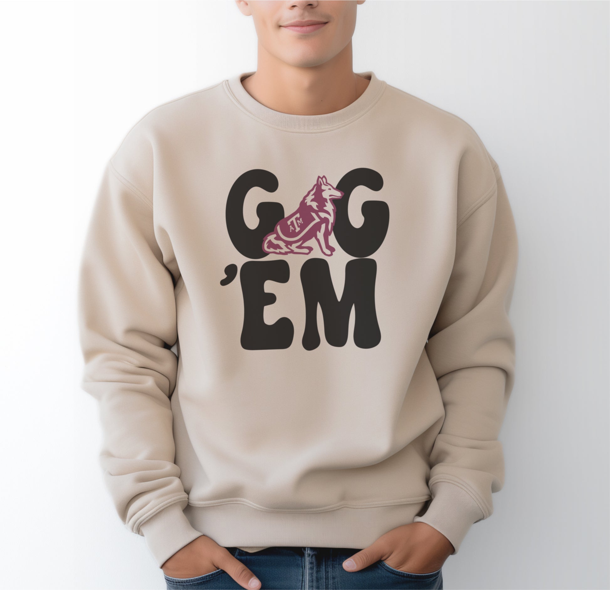 A model wears the Sand Adult Unisex Texas A&M Gig 'Em Retro Reveille Crewneck Sweatshirt.  The ﻿Texas A&M Gig 'Em Retro Reveille﻿ graphic is in bold Black in a Groovy Vintage style.