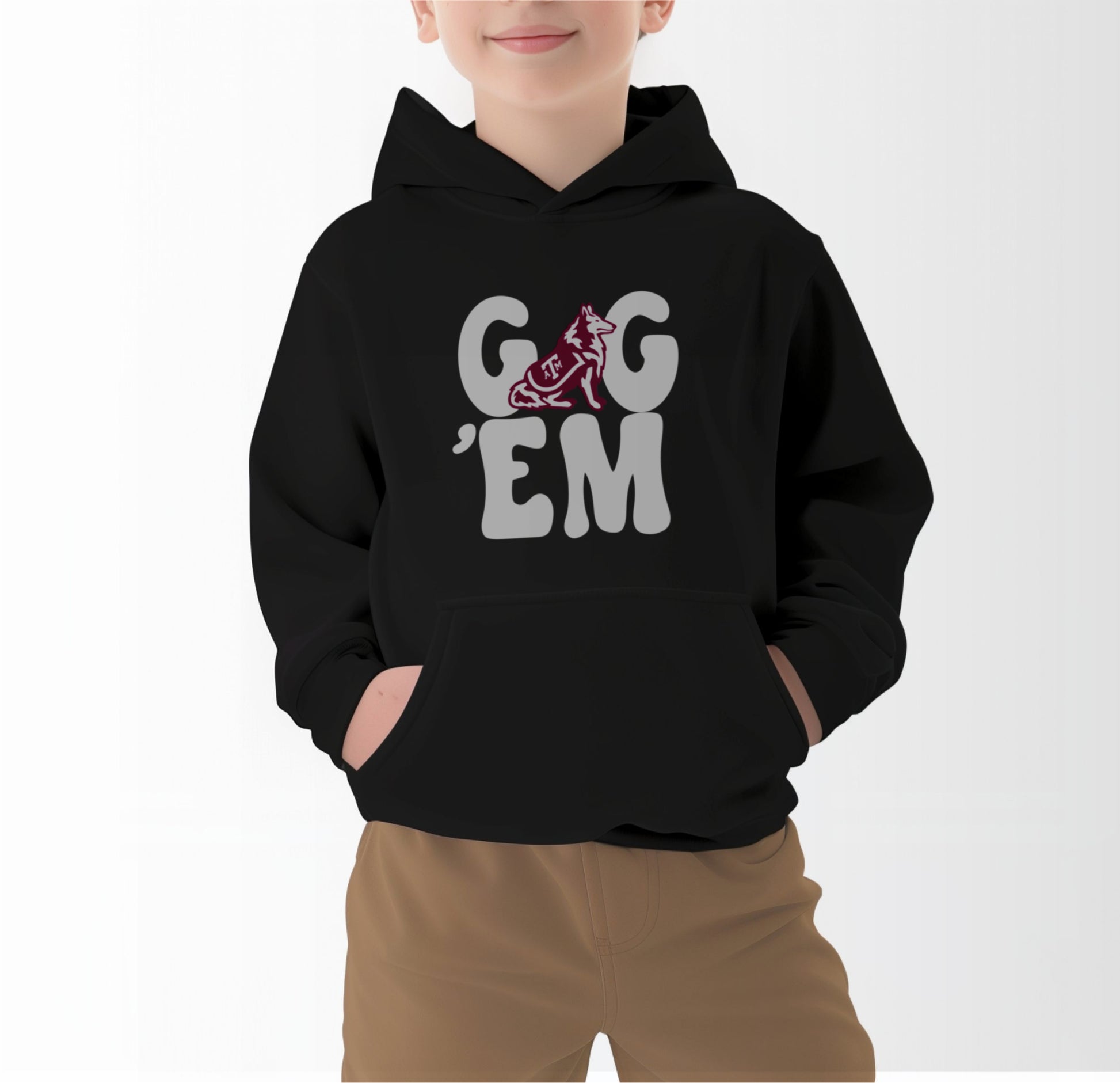 A model wears the Black Youth Unisex Texas A&M Gig 'Em Retro Reveille Hooded Sweatshirt.  The ﻿Texas A&M Gig 'Em Retro Reveille﻿ graphic is in bold White in a Groovy Vintage style.