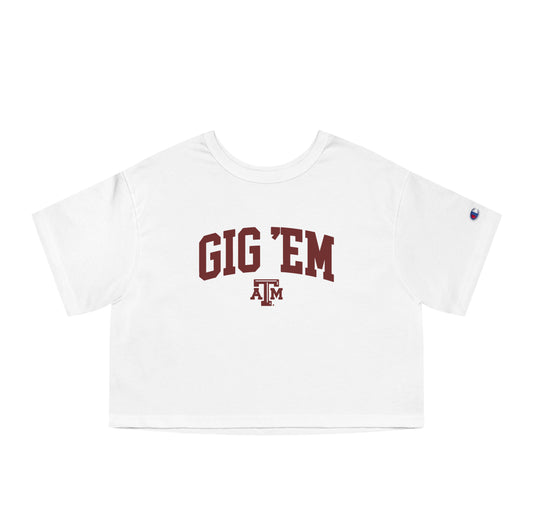 The White Adult Womens Texas A&M Gig 'Em Collegiate Crop Top lays flat on a white background. The ﻿Texas A&M Gig 'Em Collegiate﻿ graphic is in bold Maroon in a Collegiate style.