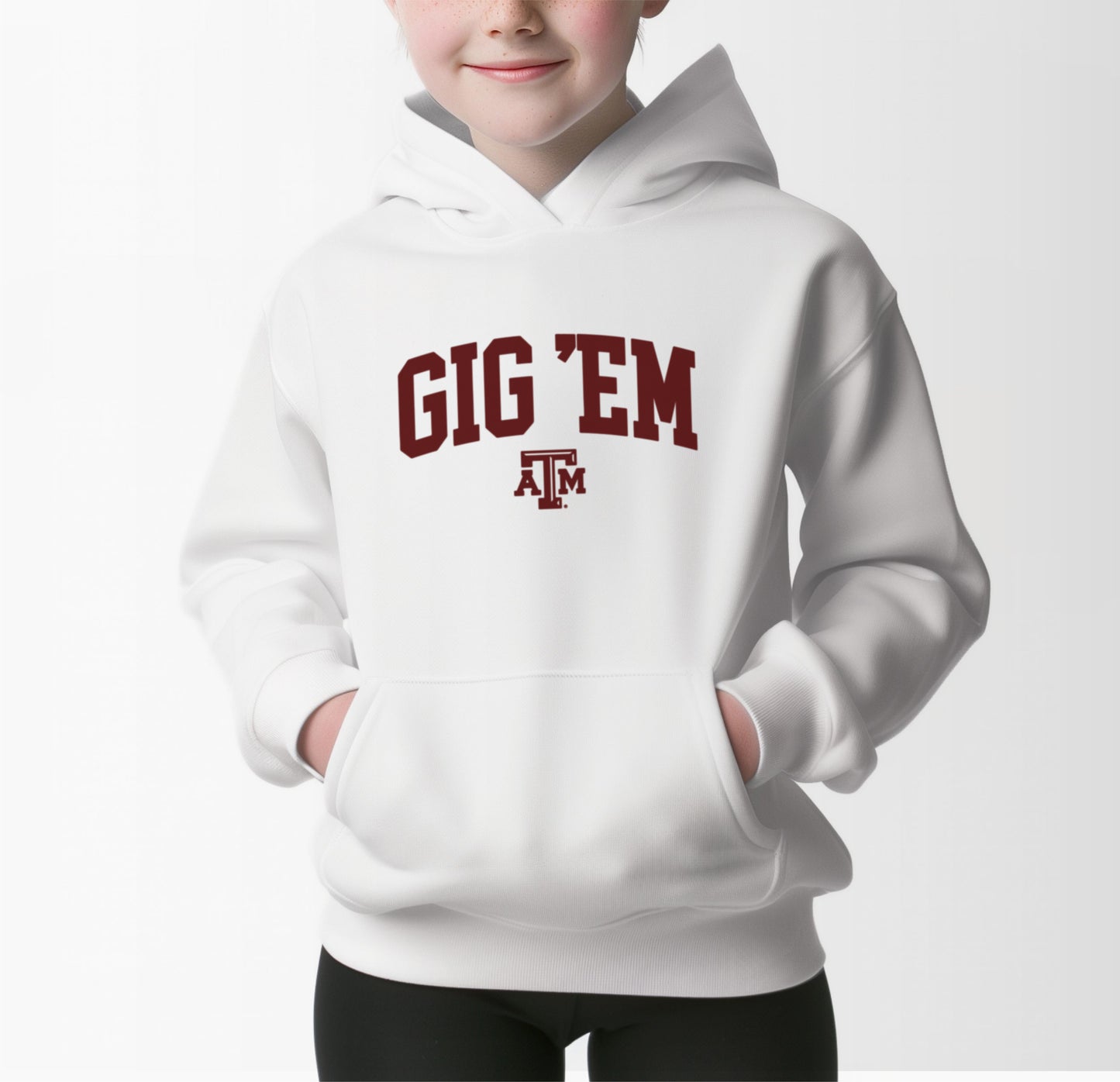 A model wears the White Youth Unisex Texas A&M Gig 'Em Collegiate Hooded Sweatshirt.  The ﻿Texas A&M Gig 'Em Collegiate﻿ graphic is in bold Maroon in a Collegiate style.