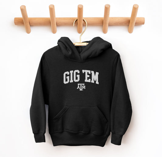 The Black Youth Unisex Texas A&M Gig 'Em Collegiate Hooded Sweatshirt lays flat on a white background. The ﻿Texas A&M Gig 'Em Collegiate﻿ graphic is in bold White in a Collegiate style.