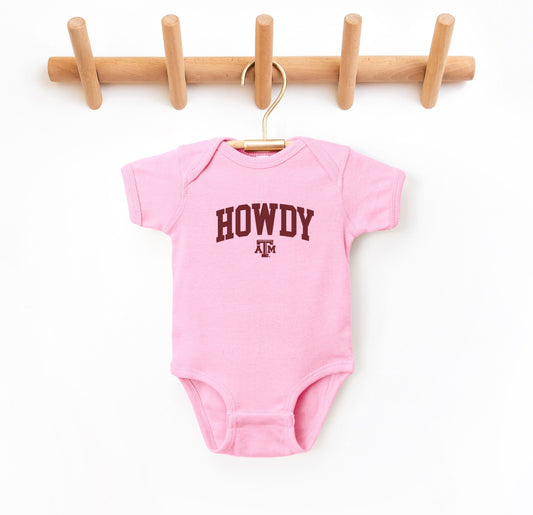 The Pink Infant Unisex Texas A&M Howdy Varsity Bodysuit lays flat on a white background. The ﻿Texas A&M Howdy Varsity﻿ graphic is in bold Maroon in a Collegiate style.