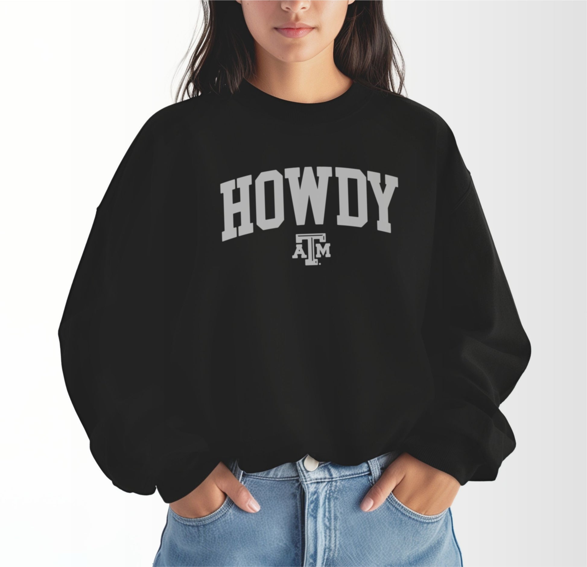 A model wears the Black Adult Unisex Texas A&M Howdy Varsity Crewneck Sweatshirt.  The ﻿Texas A&M Howdy Varsity﻿ graphic is in bold White in a Collegiate style.