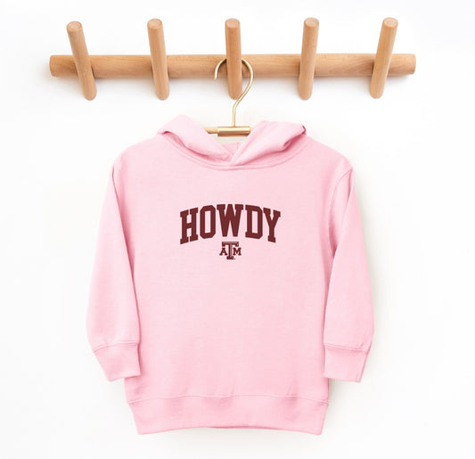 The Pink Toddler Unisex Texas A&M Howdy Varsity Hooded Sweatshirt lays flat on a white background. The ﻿Texas A&M Howdy Varsity﻿ graphic is in bold White in a Collegiate style.