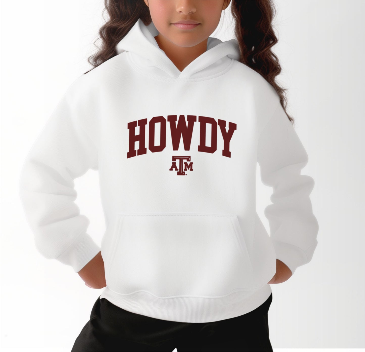 A model wears the White Youth Unisex Texas A&M Howdy Varsity Hooded Sweatshirt.  The ﻿Texas A&M Howdy Varsity﻿ graphic is in bold Maroon in a Collegiate style.