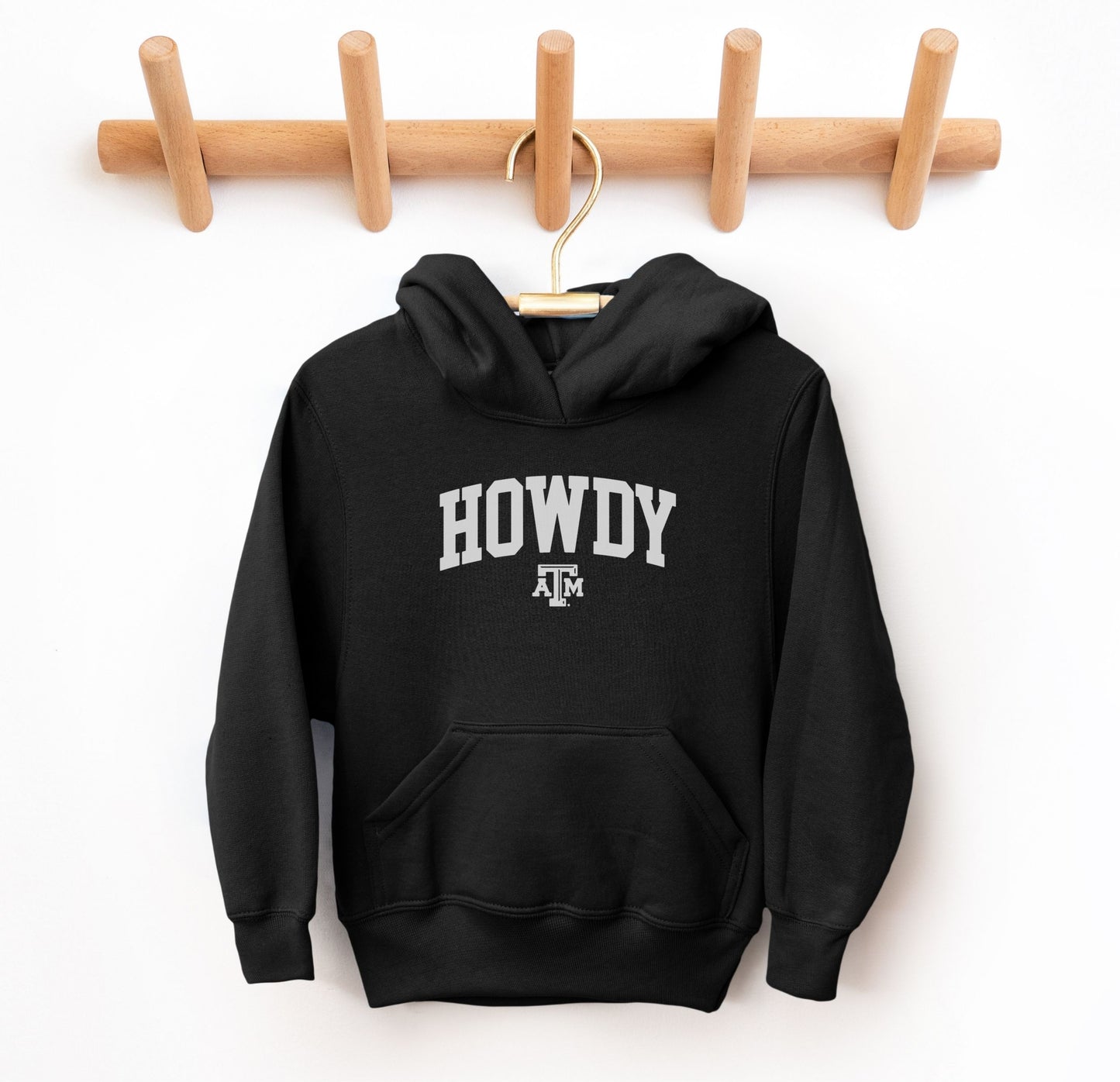 The Black Youth Unisex Texas A&M Howdy Varsity Hooded Sweatshirt lays flat on a white background. The ﻿Texas A&M Howdy Varsity﻿ graphic is in bold White in a Collegiate style.