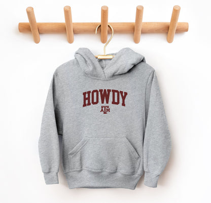 The Grey Youth Unisex Texas A&M Howdy Varsity Hooded Sweatshirt lays flat on a white background. The ﻿Texas A&M Howdy Varsity﻿ graphic is in bold Maroon in a Collegiate style.