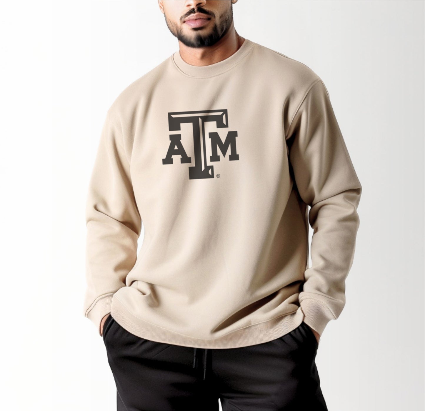 A model wears the Sand Adult Unisex Texas A&M Logo Crewneck Sweatshirt.  The ﻿Texas A&M Logo﻿ graphic is in bold Black in a Varsity style.