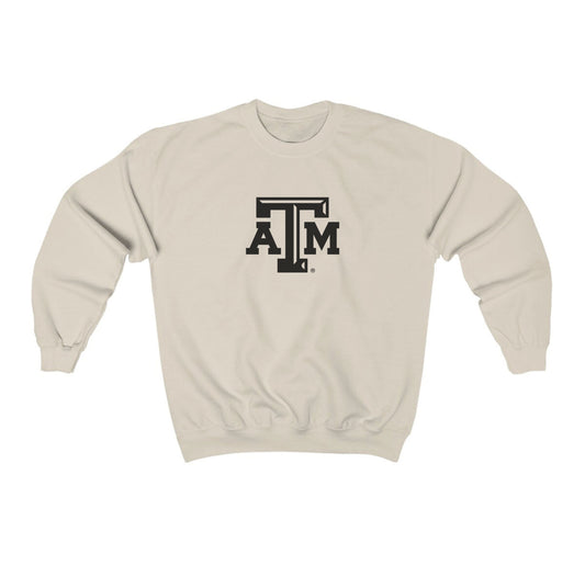 The Sand Adult Unisex Texas A&M Logo Crewneck Sweatshirt lays flat on a white background. The ﻿Texas A&M Logo﻿ graphic is in bold Black in a Varsity style.