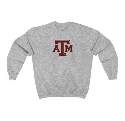 The Sport Grey Adult Unisex Texas A&M Logo Crewneck Sweatshirt lays flat on a white background. The ﻿Texas A&M Logo﻿ graphic is in bold Maroon in a Varsity style.