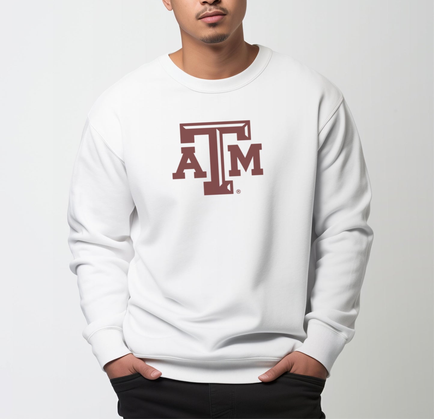 A model wears the White Adult Unisex Texas A&M Logo Crewneck Sweatshirt.  The ﻿Texas A&M Logo﻿ graphic is in bold Maroon in a Varsity style.