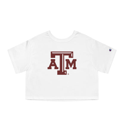 The White Adult Womens Texas A&M Logo Crop Top lays flat on a white background. The ﻿Texas A&M Logo﻿ graphic is in bold Maroon in a Varsity style.