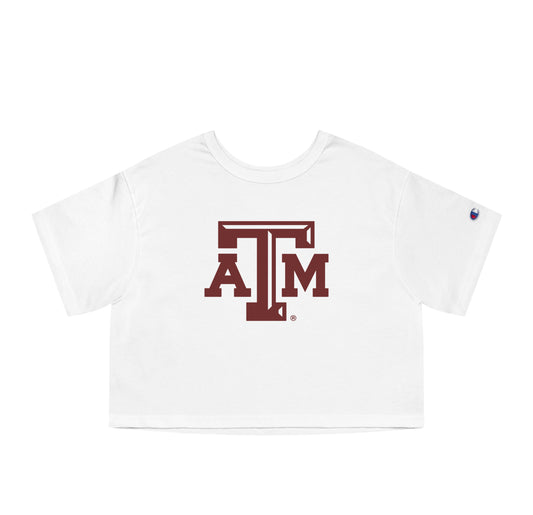 The White Adult Womens Texas A&M Logo Crop Top lays flat on a white background. The ﻿Texas A&M Logo﻿ graphic is in bold Maroon in a Varsity style.