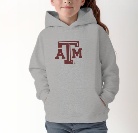 A model wears the Sport Grey Youth Unisex Texas A&M Logo Hooded Sweatshirt.  The ﻿Texas A&M Logo﻿ graphic is in bold Maroon in a Varsity style.