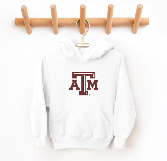 The White Youth Unisex Texas A&M Logo Hooded Sweatshirt lays flat on a white background. The ﻿Texas A&M Logo﻿ graphic is in bold Maroon in a Varsity style.