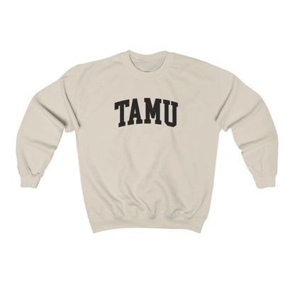 The Sand Adult Unisex Texas A&M TAMU Crewneck Sweatshirt lays flat on a white background. The ﻿Texas A&M TAMU﻿ graphic is in bold Black in a Collegiate style.