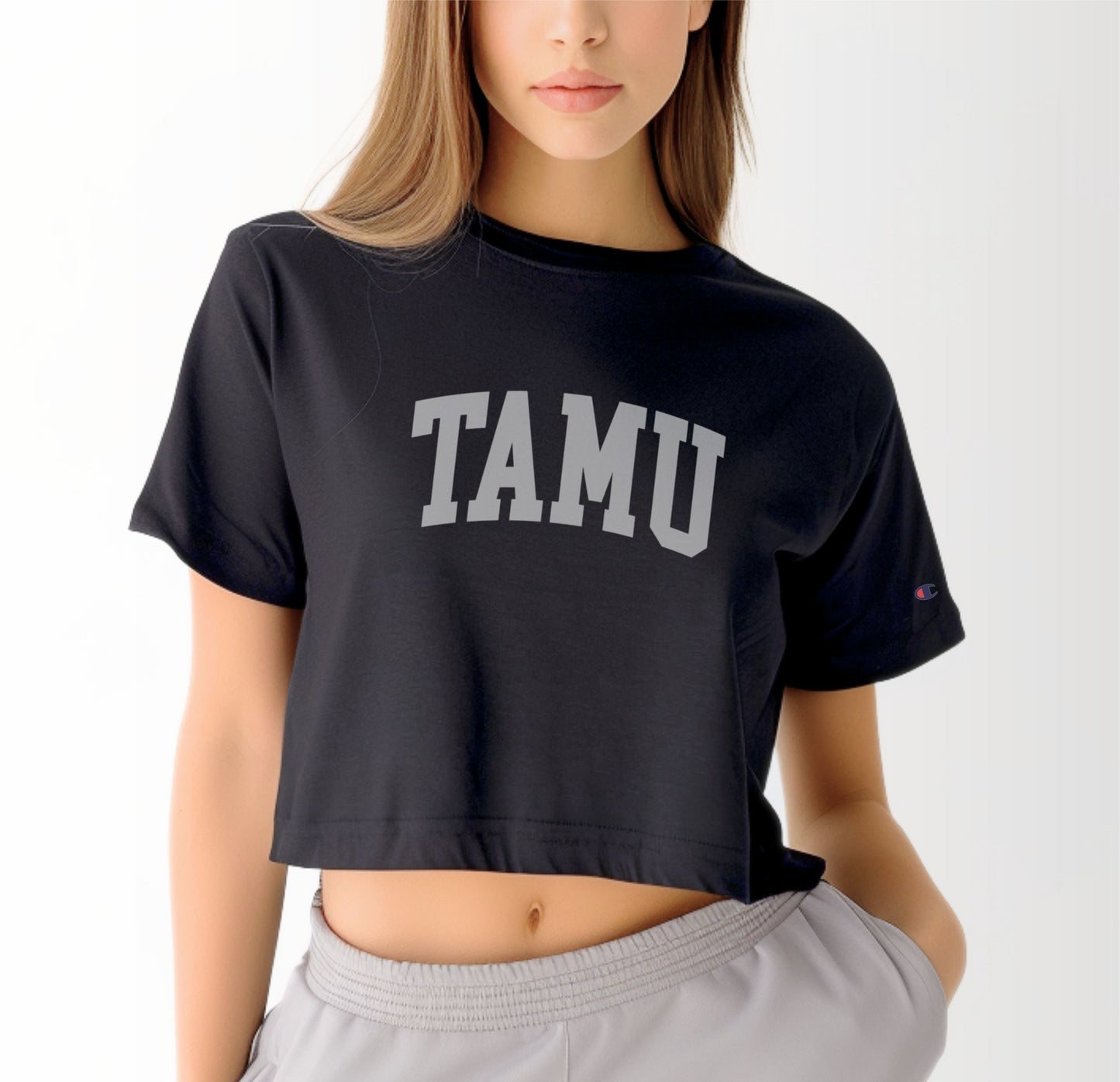 A model wears the Black Adult Womens Texas A&M TAMU Crop Top.  The ﻿Texas A&M TAMU﻿ graphic is in bold White in a Collegiate style.