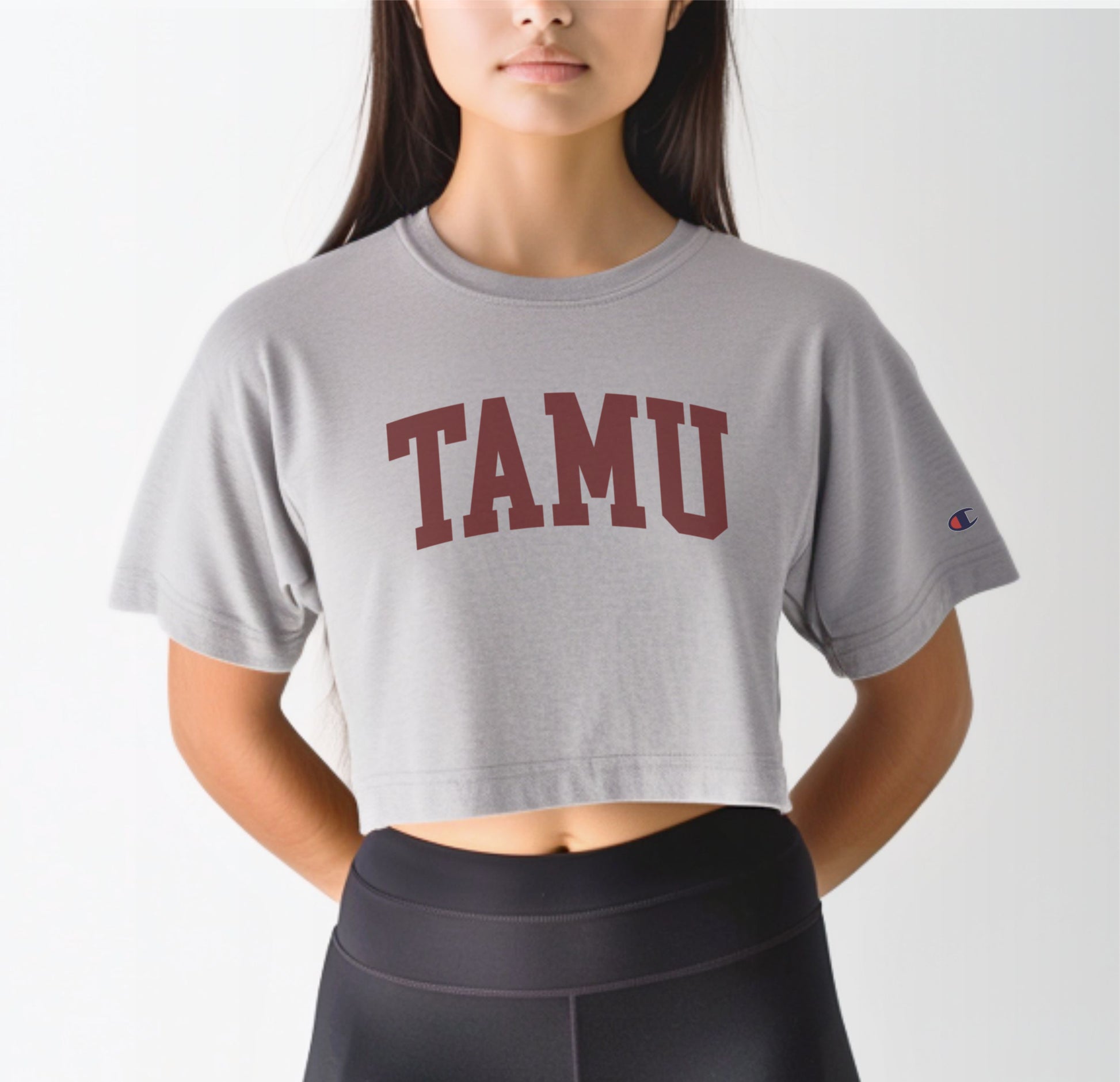 A model wears the Oxford Grey Adult Womens Texas A&M TAMU Crop Top.  The ﻿Texas A&M TAMU﻿ graphic is in bold Maroon in a Collegiate style.