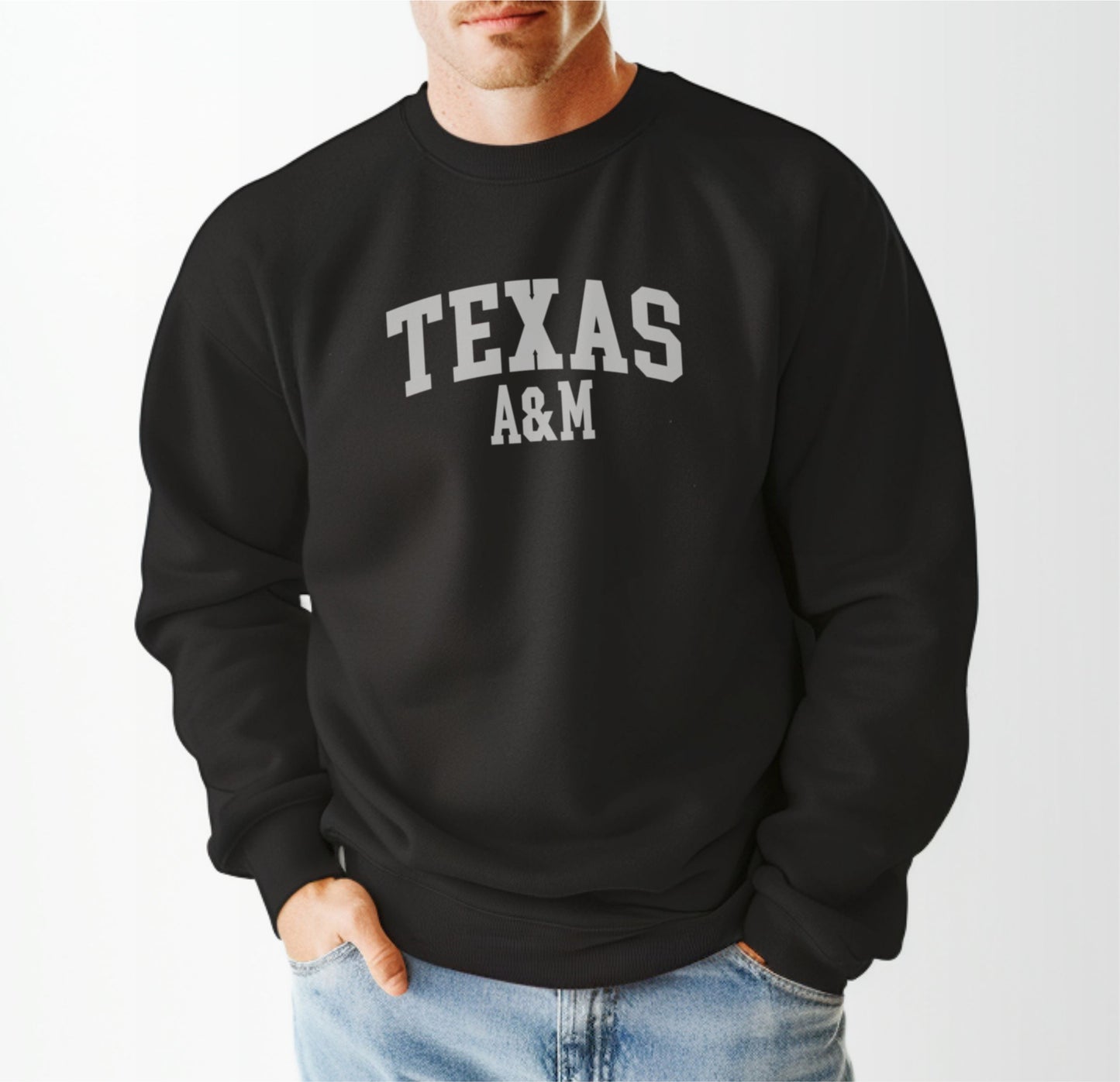 A model wears the Black Adult Unisex Texas A&M Varsity Crewneck Sweatshirt.  The ﻿Texas A&M Varsity﻿ graphic is in bold White in a Collegiate style.