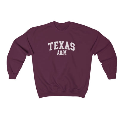 The Maroon Adult Unisex Texas A&M Varsity Crewneck Sweatshirt lays flat on a white background. The ﻿Texas A&M Varsity﻿ graphic is in bold White in a Collegiate style.