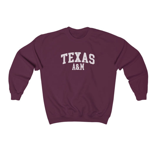 The Maroon Adult Unisex Texas A&M Varsity Crewneck Sweatshirt lays flat on a white background. The ﻿Texas A&M Varsity﻿ graphic is in bold White in a Collegiate style.