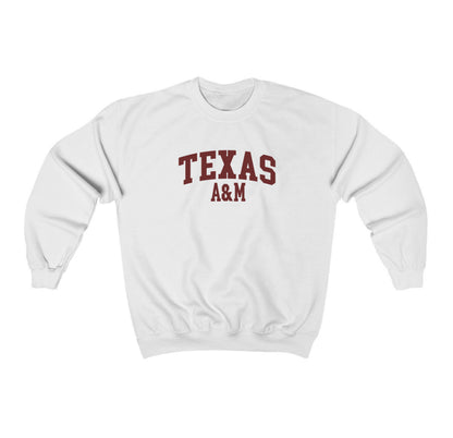 The White Adult Unisex Texas A&M Varsity Crewneck Sweatshirt lays flat on a white background. The ﻿Texas A&M Varsity﻿ graphic is in bold Maroon in a Collegiate style.