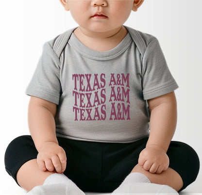 A model wears the Black Infant Unisex Texas A&M Western Bodysuit.  The ﻿Texas A&M Western﻿ graphic is in bold White in a Western style.