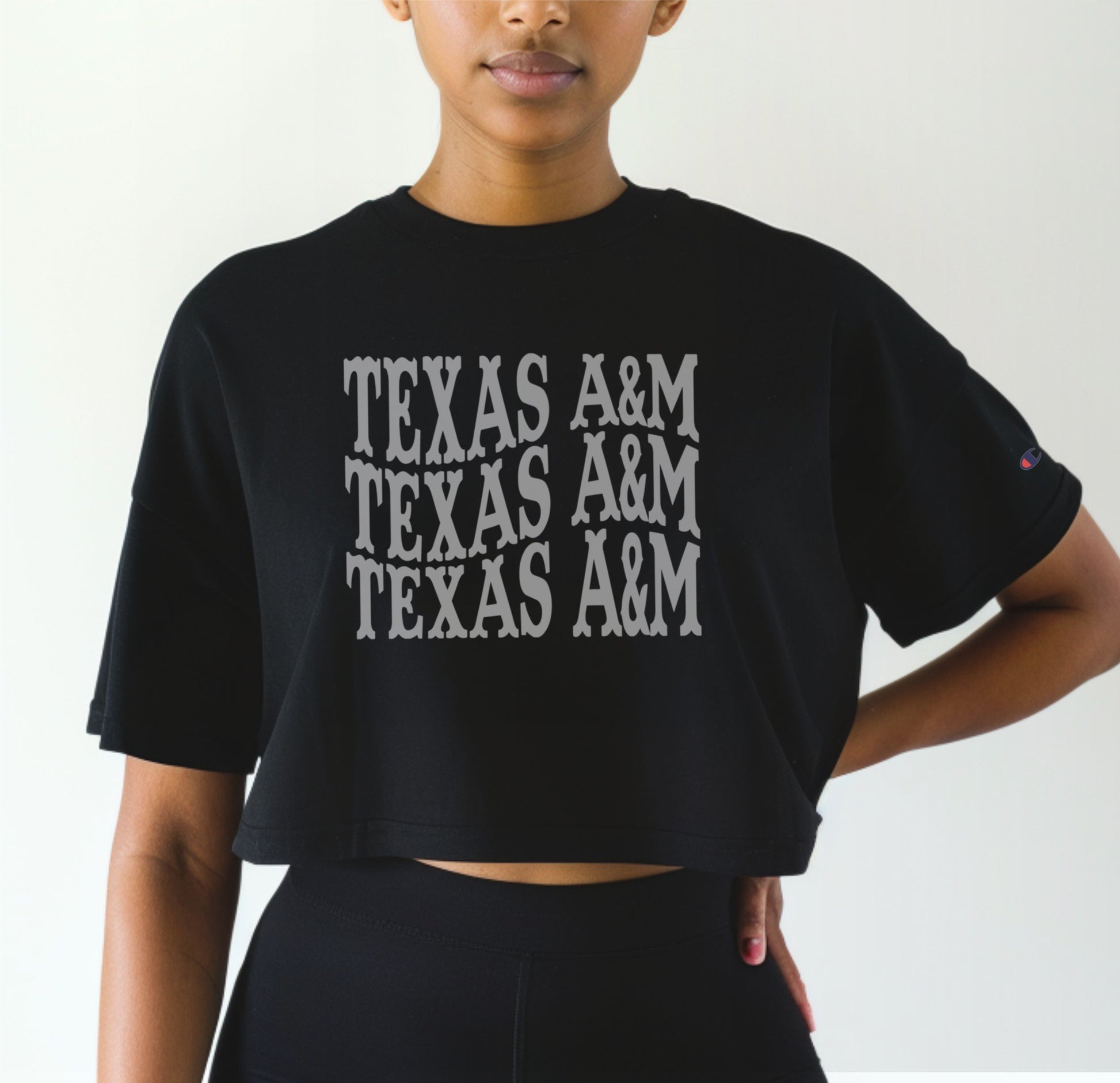 A model wears the Black Adult Womens Texas A&M Western Crop Top.  The ﻿Texas A&M Western﻿ graphic is in bold White in a Western style.