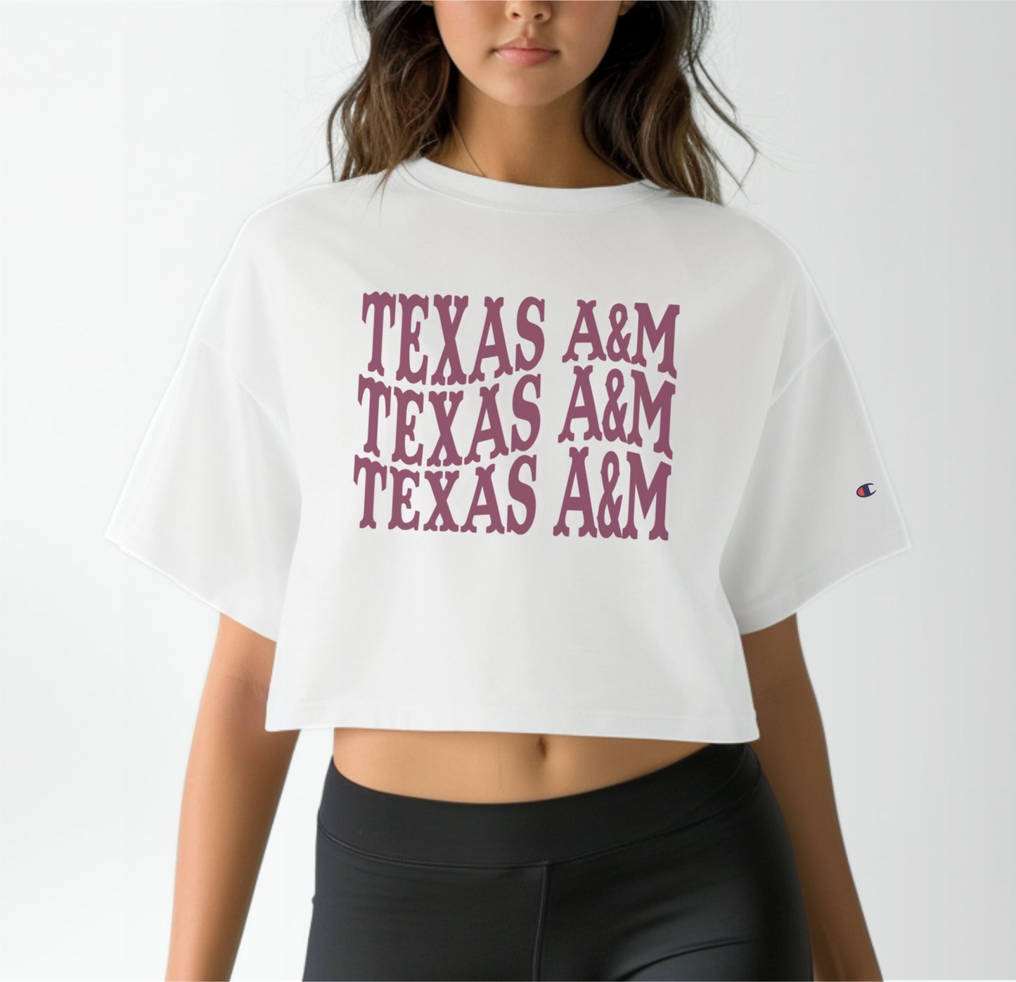 A model wears the White Adult Womens Texas A&M Western Crop Top.  The ﻿Texas A&M Western﻿ graphic is in bold Maroon in a Western style.