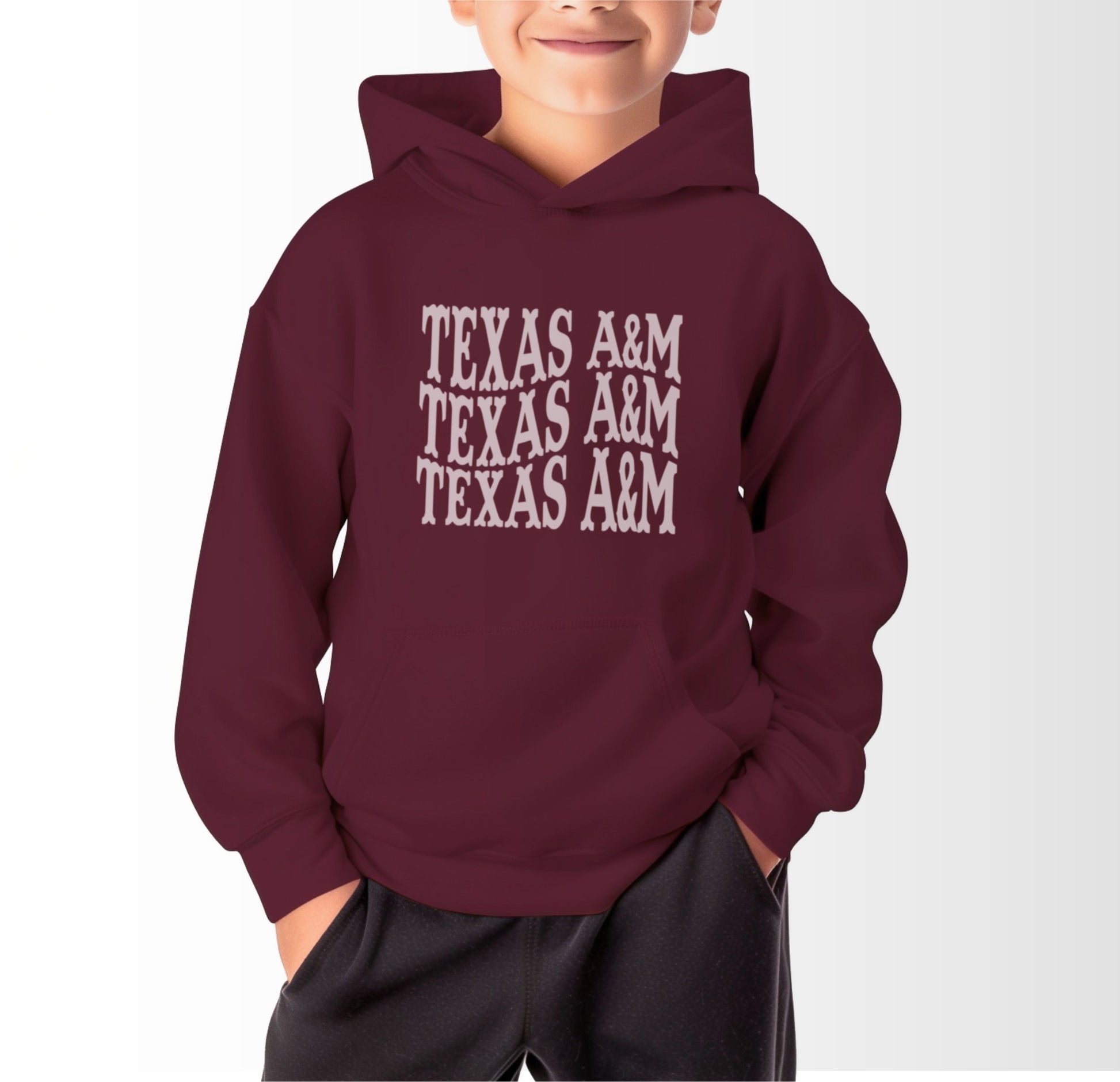 A model wears the Maroon Youth Unisex Texas A&M Western Hooded Sweatshirt.  The ﻿Texas A&M Western﻿ graphic is in bold White in a Western style.