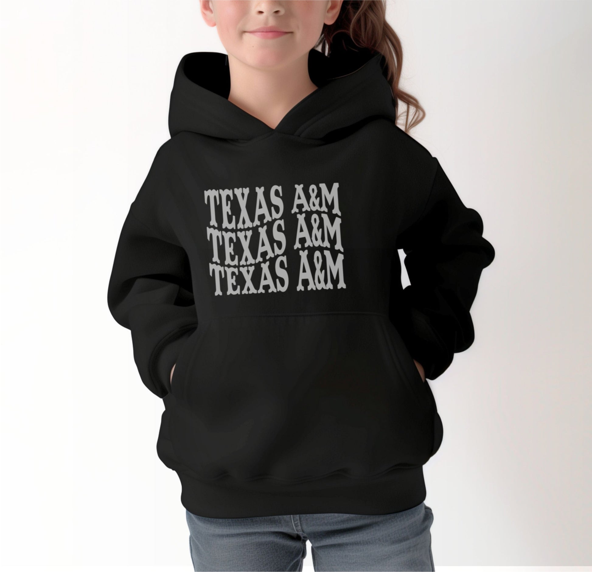 A model wears the Black Youth Unisex Texas A&M Western Hooded Sweatshirt.  The ﻿Texas A&M Western﻿ graphic is in bold White in a Western style.